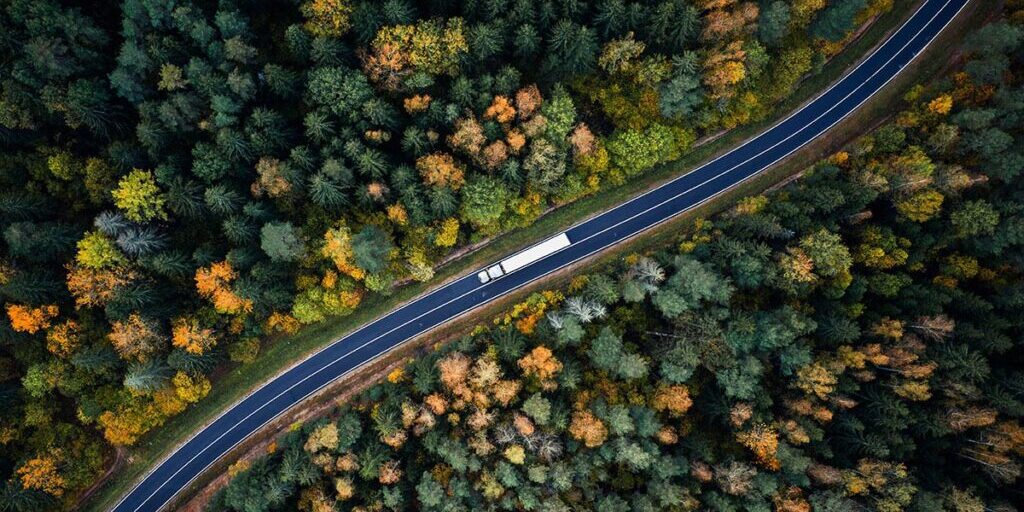 Navigating The 2024 Freight Landscape ATS FREEWAY   DAT Equipment Aerial View Forest Road With Truck 1200x628 1024x536 1 1024x512 